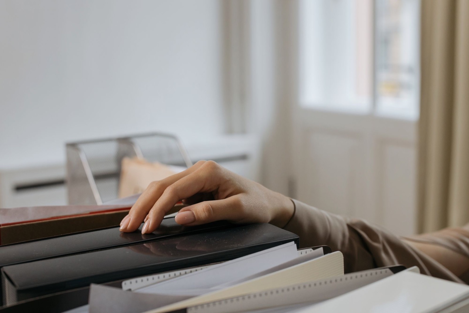 A hand resting on a row of file folders
