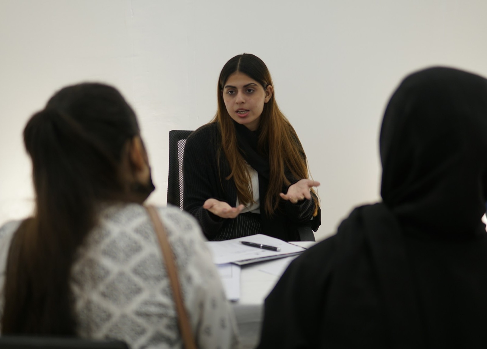An advocate explaining a matter to two clients across a desk
