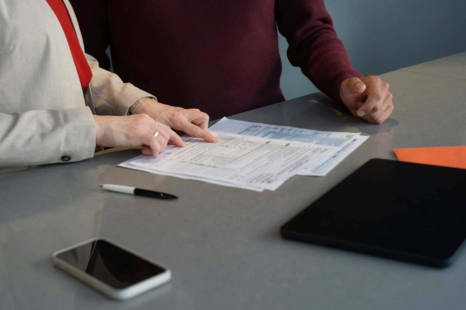 Two people going over printed forms at a table